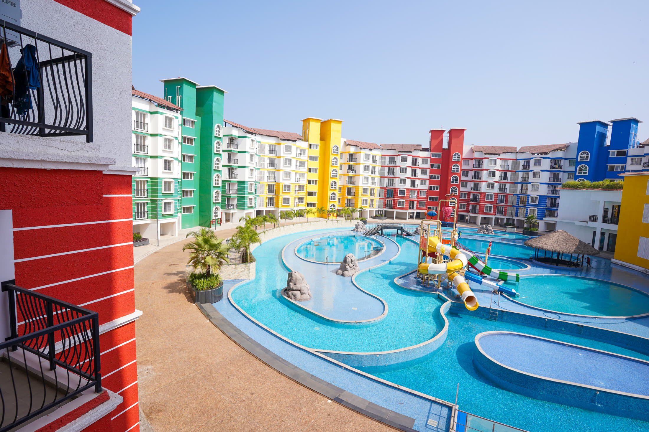 Outdoor pool and colourful buildings at Adora De Goa